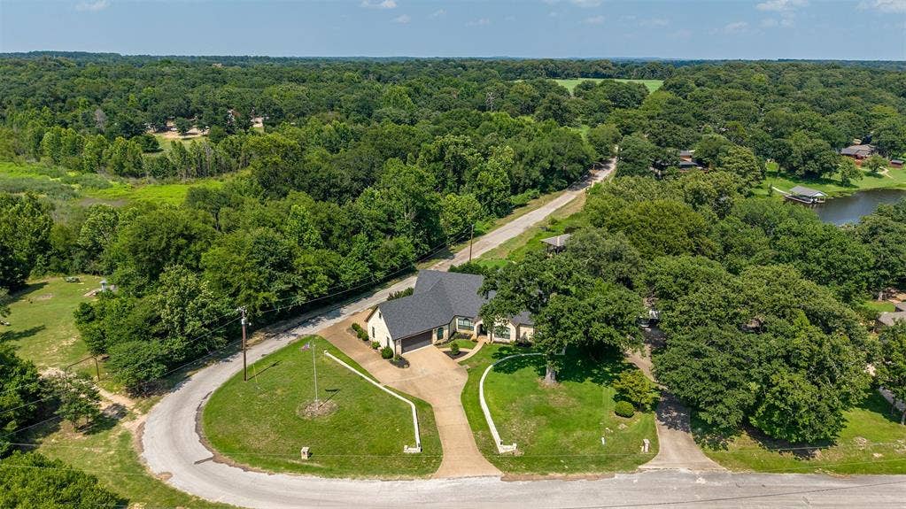 6414 Dorsey Drive, Athens, TX 75752 Single-story residence featuring an attached two-car garage, light-colored exterior siding, and a dark shingled roof