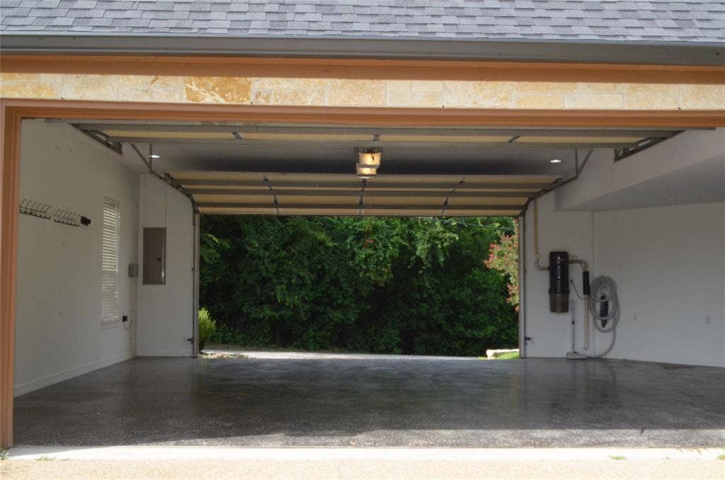 6414 Dorsey Drive, Athens, TX 75752 drive through garage -coated concrete floor, an overhead garage door, built-in central vacuum system, recessed lighting, and a window with blinds