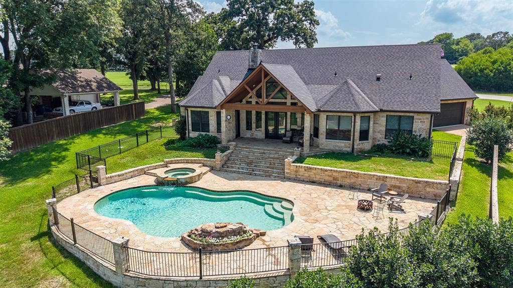 6414 Dorsey Drive, Athens, TX 75752 Backyard oasis featuring a freeform swimming pool, integrated spa, and expansive stone patio