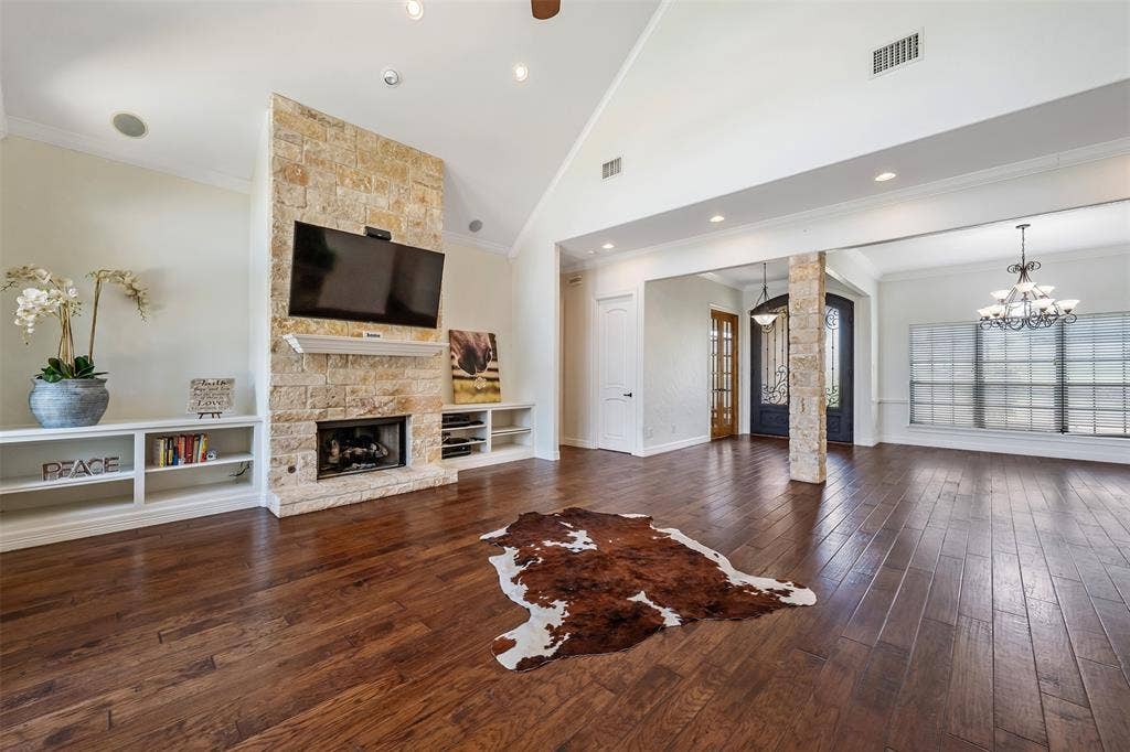 6414 Dorsey Drive, Athens, TX 75752 Spacious interior featuring wood-finish flooring, a stone-clad fireplace with built-in shelving, vaulted ceilings, and recessed lighting