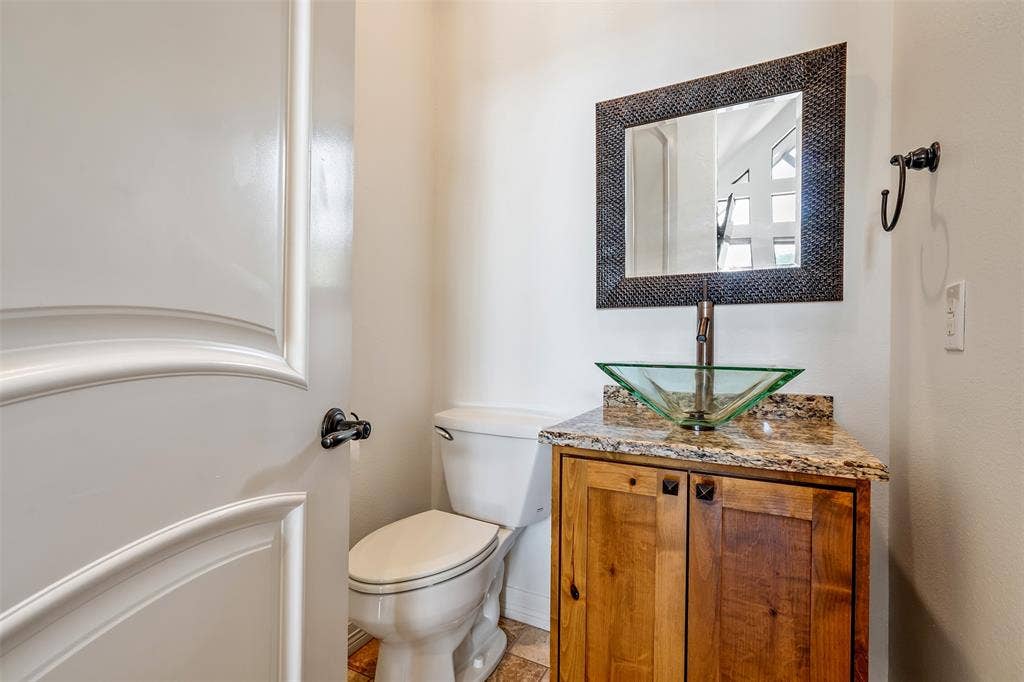 6414 Dorsey Drive, Athens, TX 75752 Bathroom featuring a natural wood-finish vanity with a granite countertop and a glass vessel sink