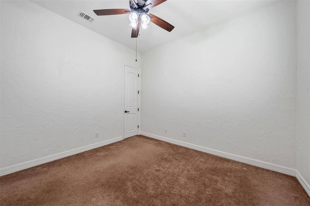 6414 Dorsey Drive, Athens, TX 75752 Neutral-toned room featuring a ceiling fan with integrated lighting, textured white walls, white trim, and brown carpet flooring