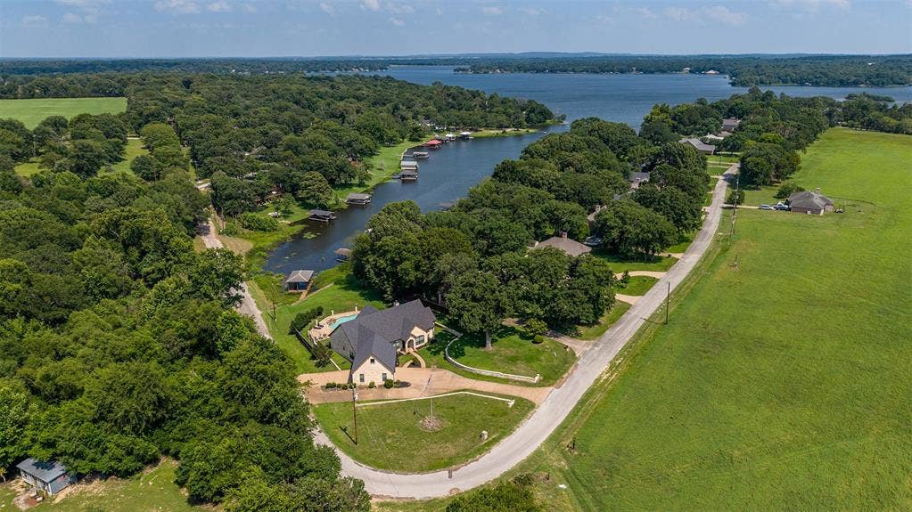 6414 Dorsey Drive, Athens, TX 75752 Expansive lakefront property featuring a private boat dock, inground swimming pool, and mature tree coverage
