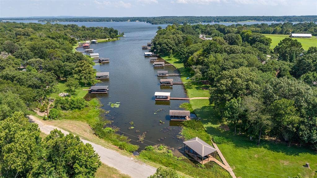 6414 Dorsey Drive, Athens, TX 75752 Waterfront canal property featuring multiple boat docks, extensive green space, and mature trees