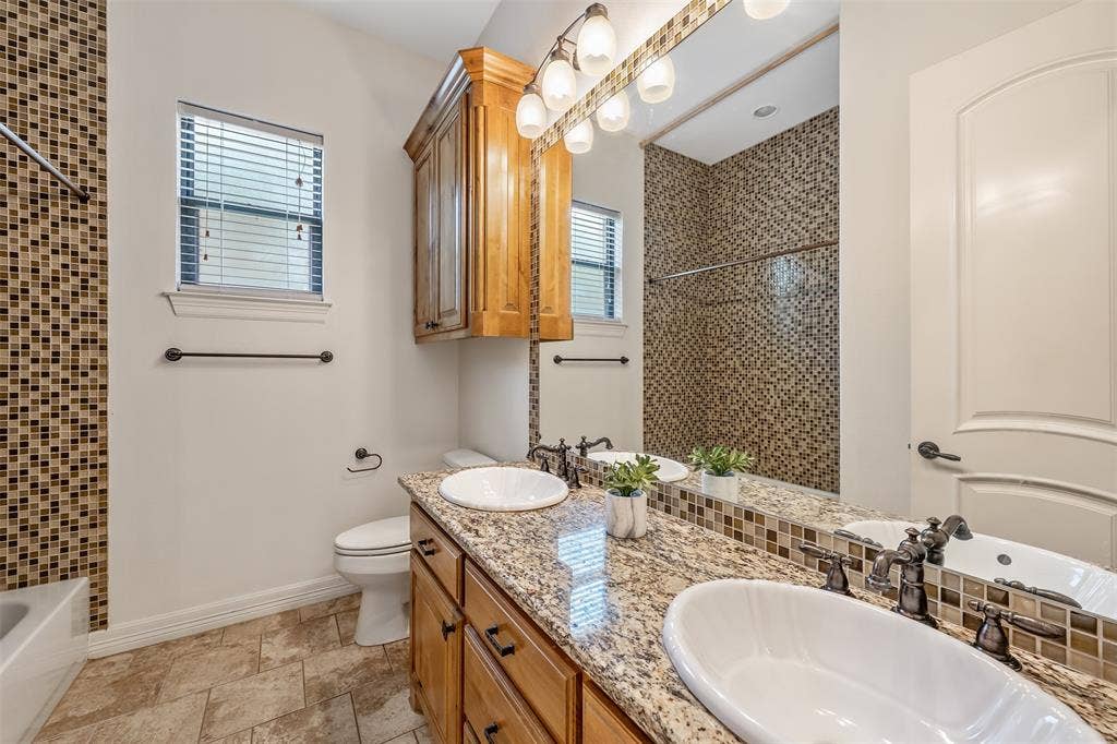 6414 Dorsey Drive, Athens, TX 75752 Bathroom featuring a dual vanity with granite-finish countertop, wood-finish cabinetry, and vessel sinks
