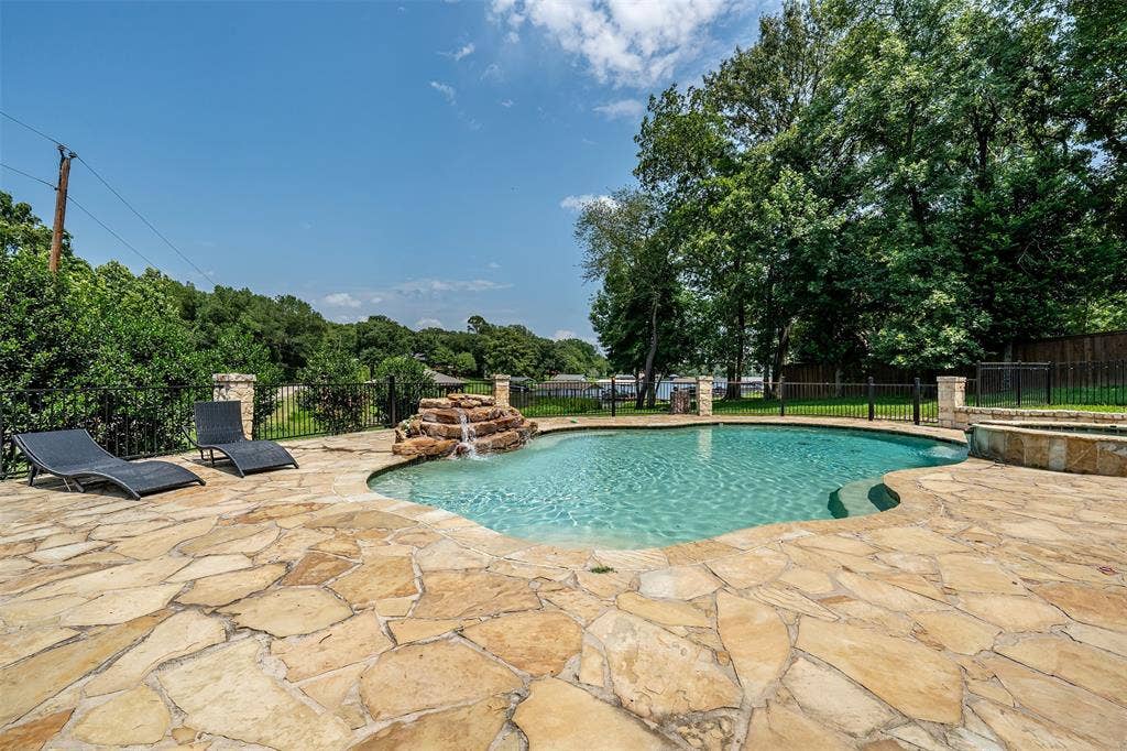 6414 Dorsey Drive, Athens, TX 75752 Freeform swimming pool with rock waterfall feature, flagstone patio, and integrated spa