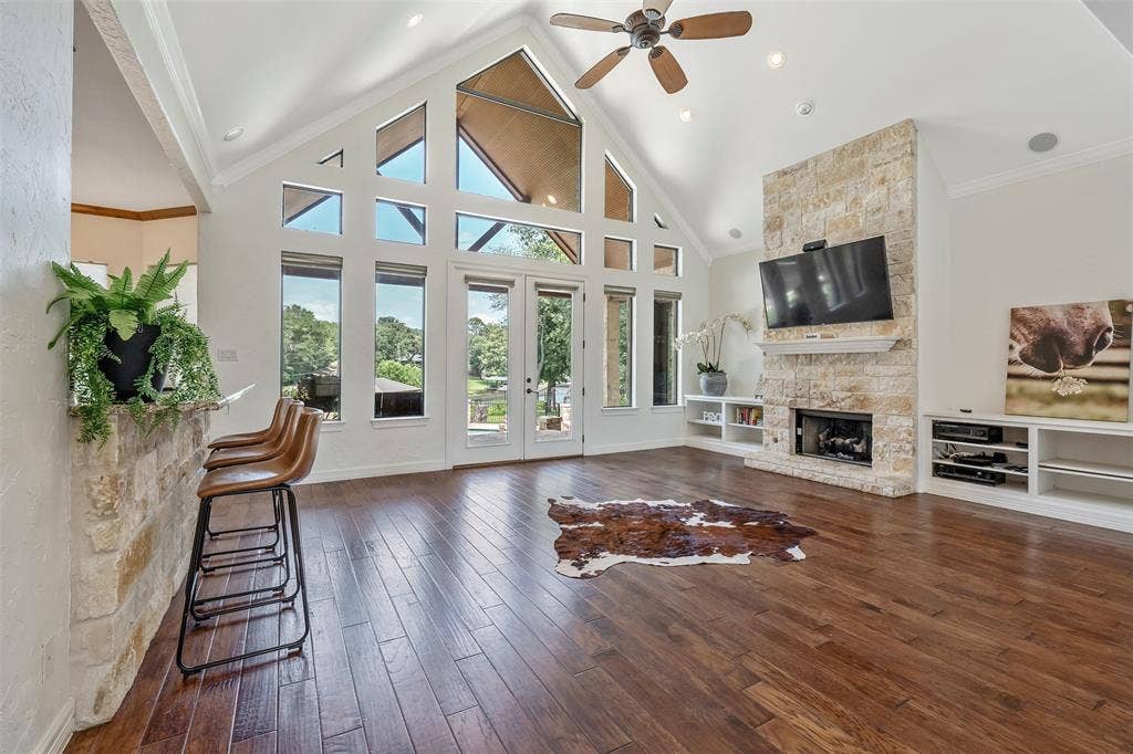 6414 Dorsey Drive, Athens, TX 75752 Living area featuring an expansive vaulted ceiling with exposed beams, wood-finish flooring, a stone-clad fireplace, and built-in shelving