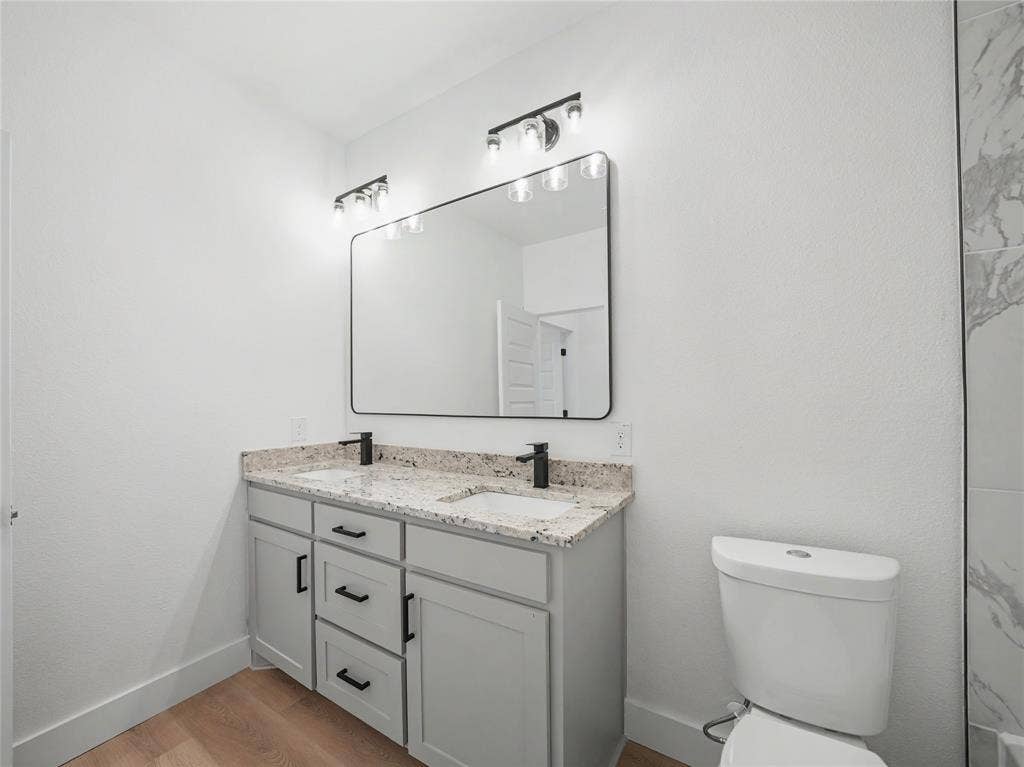 113 Dennis Drive, Azle, TX 76020 Bathroom featuring a double vanity with light gray cabinetry, speckled countertops, and matte black fixtures