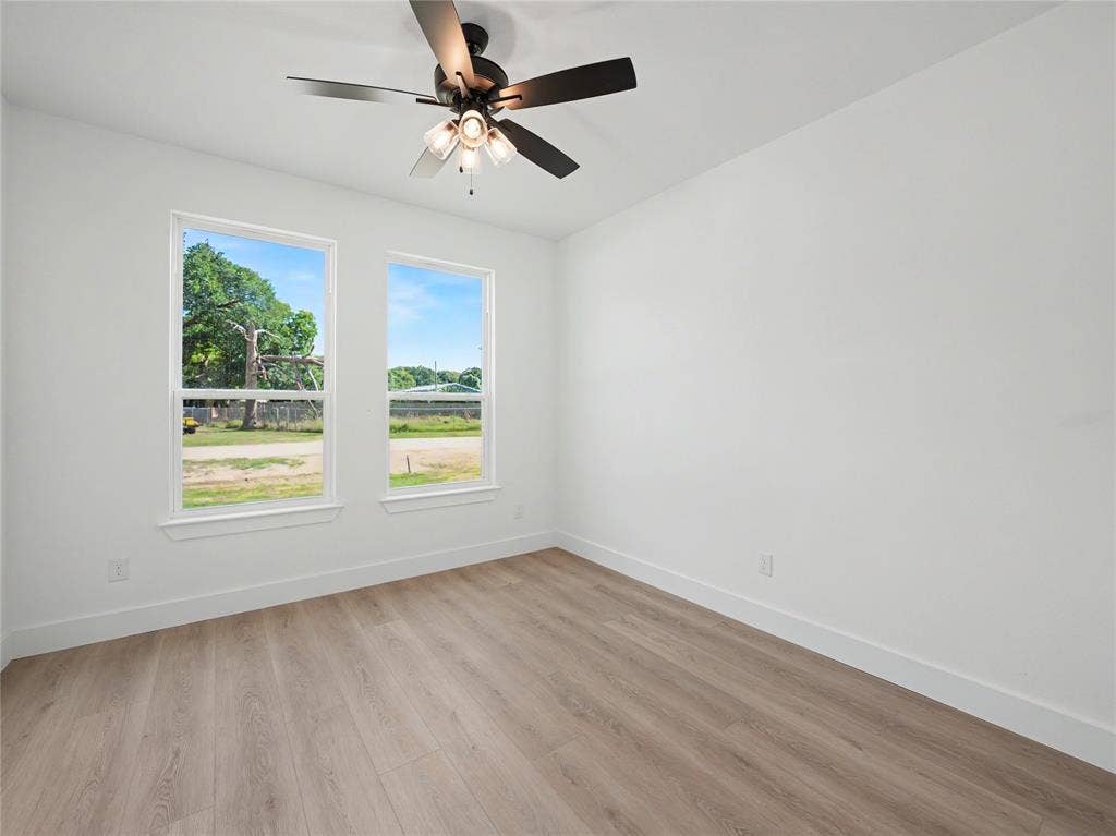 113 Dennis Drive, Azle, TX 76020 Room featuring wood-finish flooring, white baseboards, and two windows with white trim