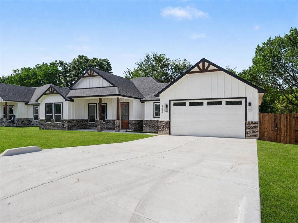 113 Dennis Drive, Azle, TX 76020 Modern farmhouse exterior featuring white board and batten siding, dark stone accents, and a contrasting dark roof