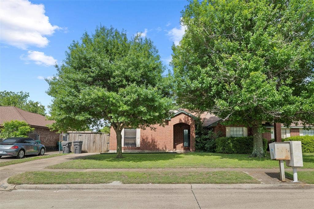 Obstructed view of property with brick siding and concrete driveway