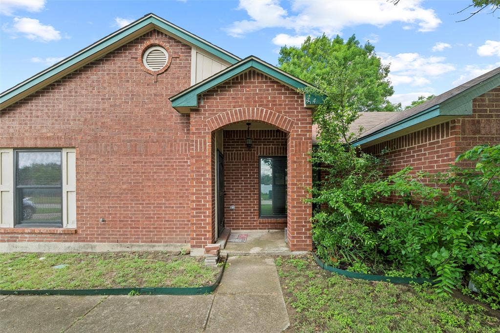View of exterior entry with brick siding