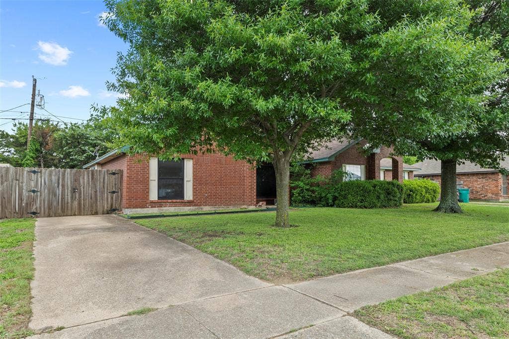 Obstructed view of property featuring brick siding, a gate, and concrete driveway