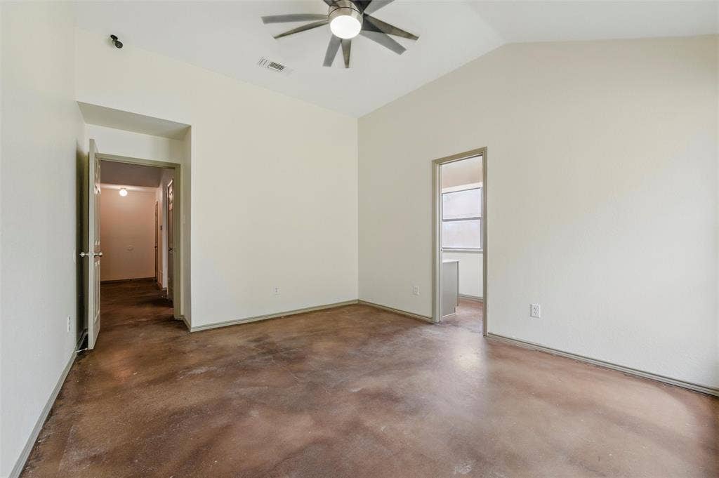 Unfurnished room featuring ceiling fan, concrete flooring, and vaulted ceiling