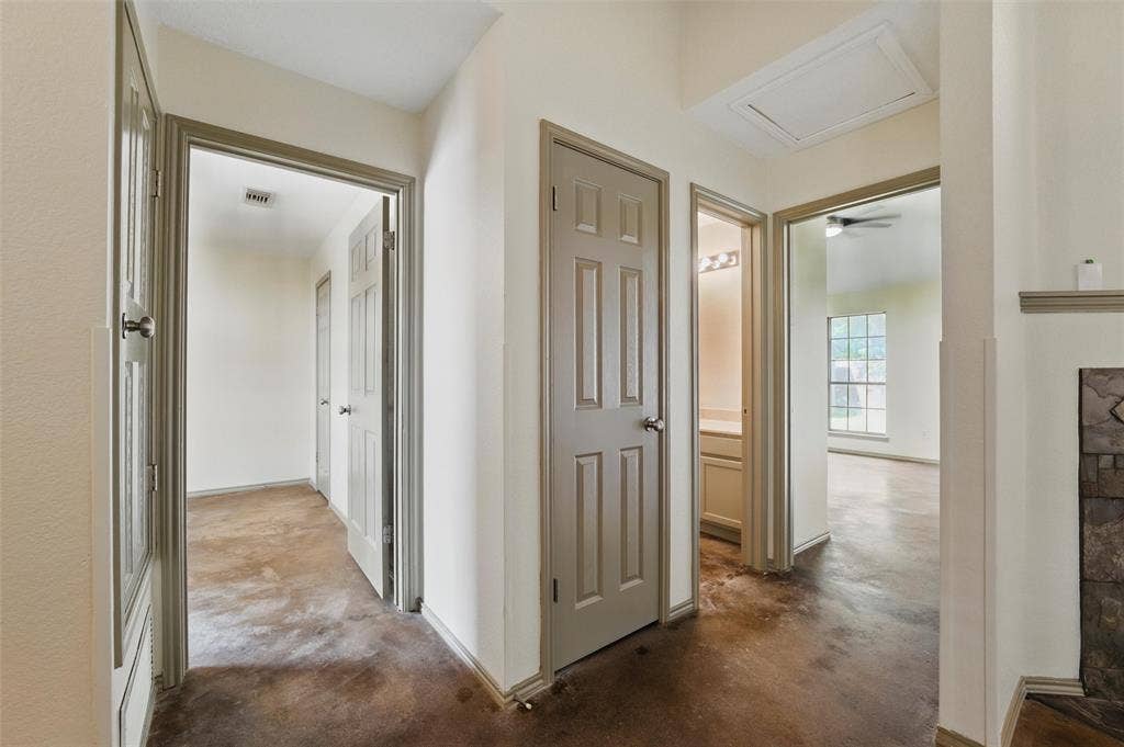 Hall featuring concrete floors and attic access