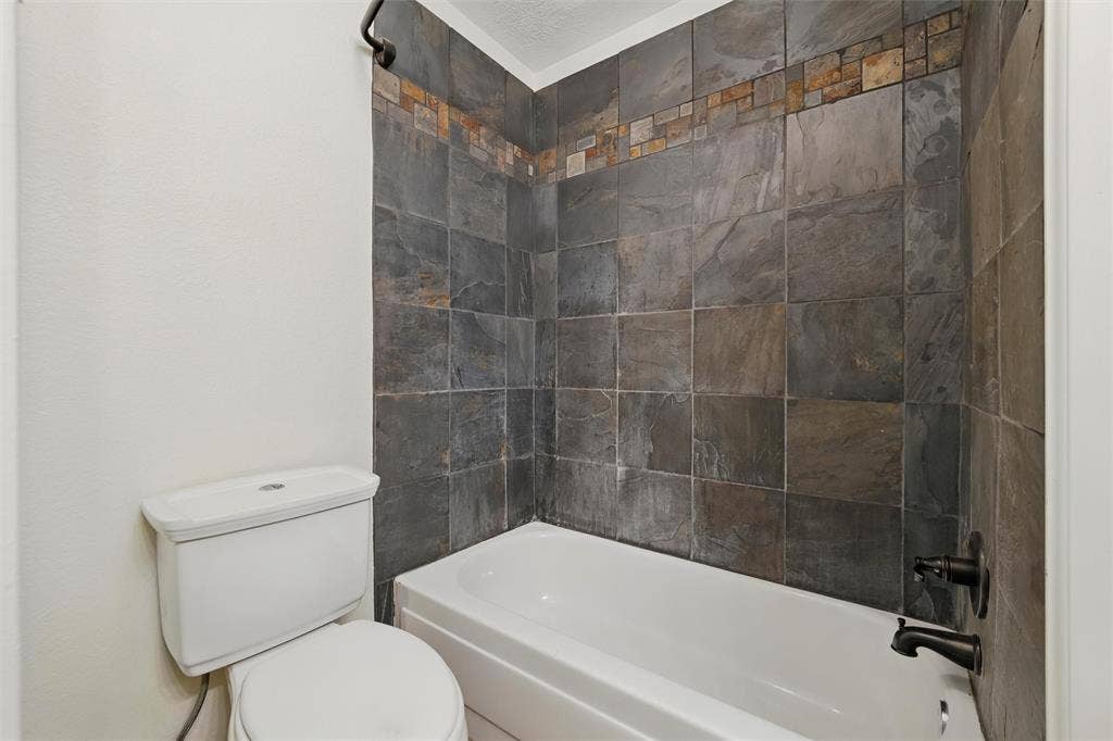 Bathroom featuring toilet and tub / shower combination