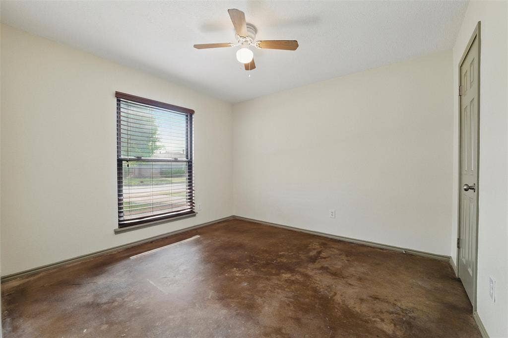 Spare room with concrete flooring and a ceiling fan