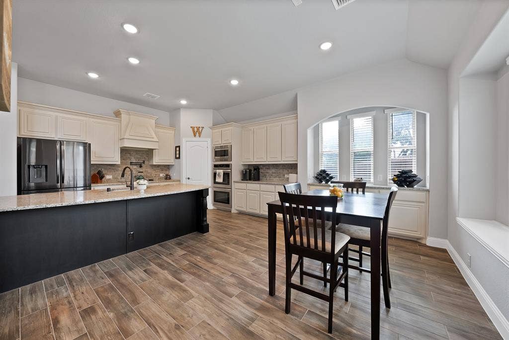 Spacious kitchen featuring wood-finish flooring, recessed lighting, and an expansive island with a light-colored countertop
