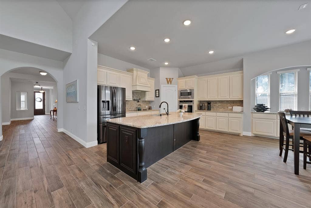 Spacious kitchen featuring a large island with granite countertop, stainless steel appliances, and abundant cabinetry