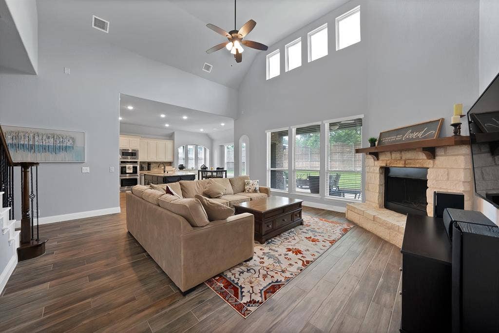 Spacious living area featuring high vaulted ceilings, clerestory windows, and wood-finish flooring