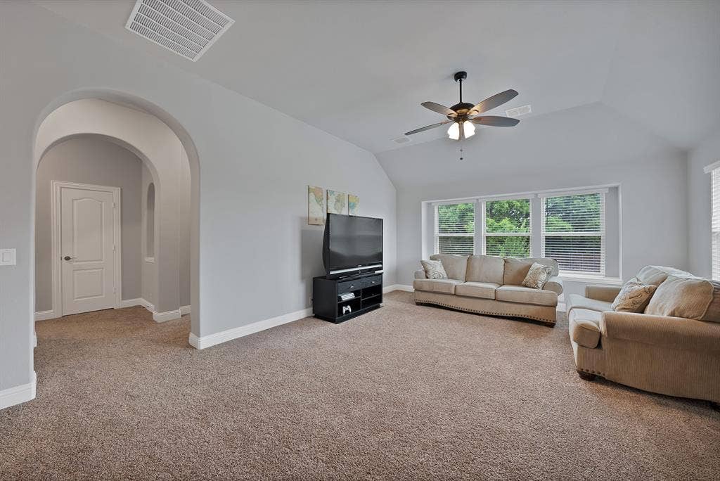 Spacious living area featuring neutral carpeting and light gray walls