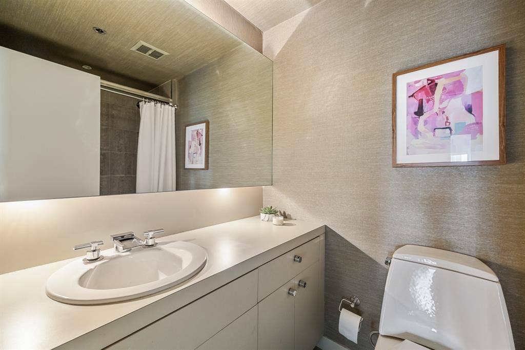 3030 Mckinney Avenue, #701, Dallas, TX 75204 Full bath featuring an expansive vanity, oversized mirror, and textured wallcovering.