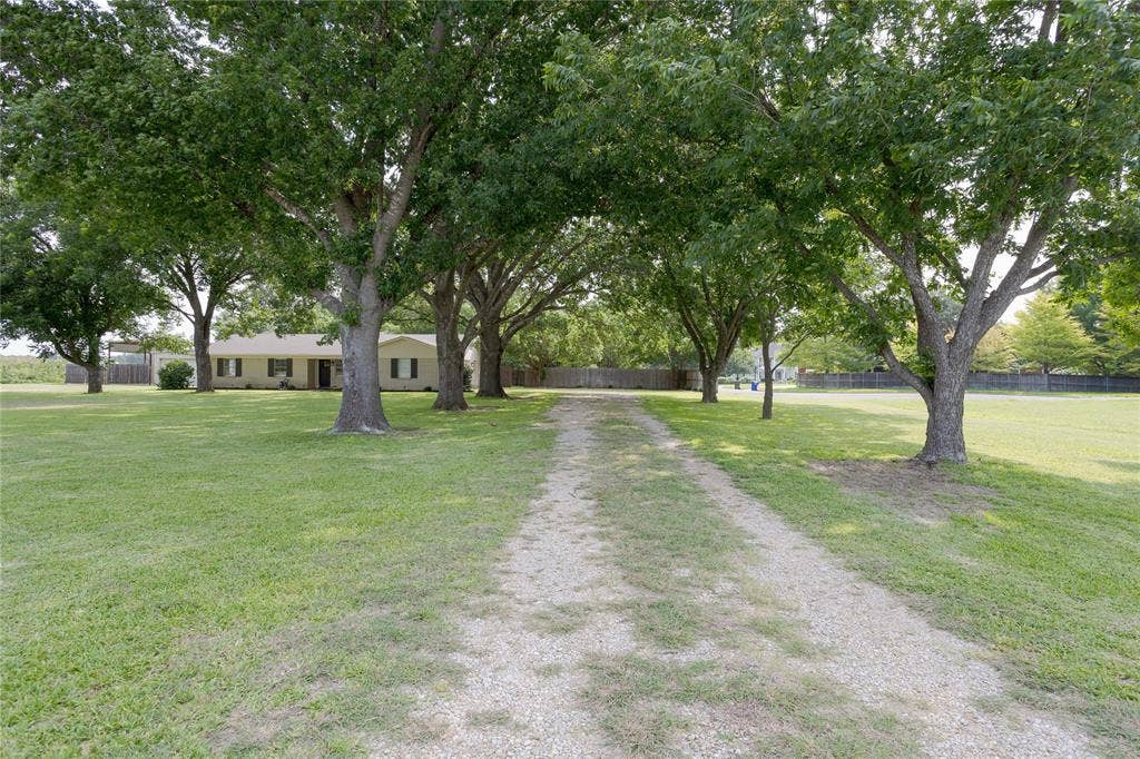 3999 Speegleville Road, Waco, TX 76712 Beautiful tree lined driveway.This home features two driveways, one to the attached garage and another to the shop and covered RV parking.