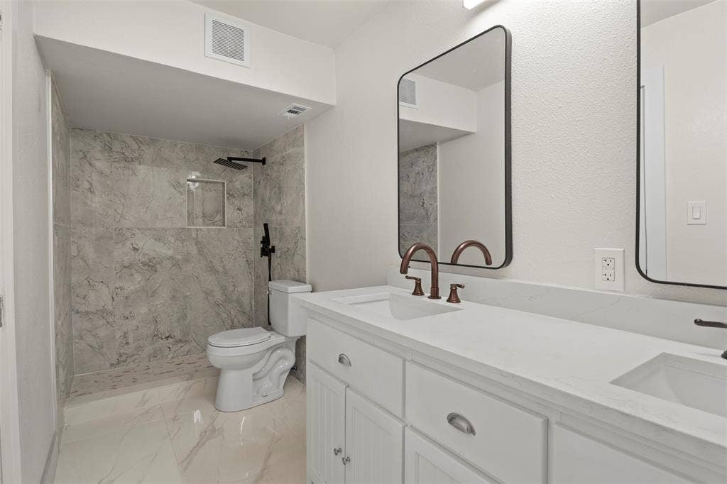 Contemporary bathroom featuring a spacious walk-in shower with marble-finish tile, a built-in shower niche, and matte black fixtures
