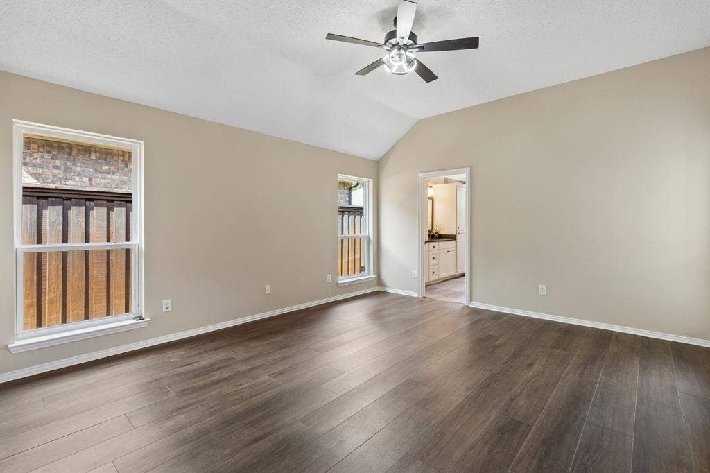 607 Grimsworth Court, Allen, TX 75002 The spacious primary bedroom has high ceiling, laminate flooring, en suite bathroom and walk in closet.