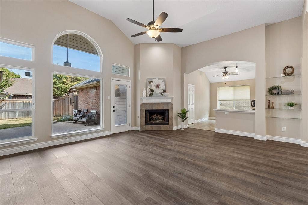 607 Grimsworth Court, Allen, TX 75002 The living room enjoys a fireplace with attractivetile surround and gas logs. Being situated at the back of the home, the wall of windows provide abundant natural light and look out over the lush backyard.