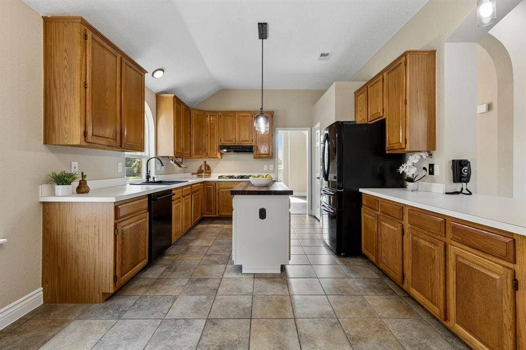 607 Grimsworth Court, Allen, TX 75002 The kitchen features updated light fixture over the island, composite double sink, black fixtures , freshly painted throughout andblack appliances.
