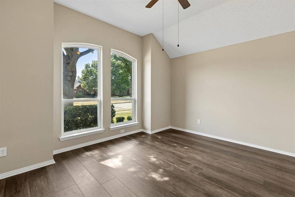 607 Grimsworth Court, Allen, TX 75002 Secondary bedroom has laminate flooring, fresh paint, ceiling fan, and vaulted ceiling.
