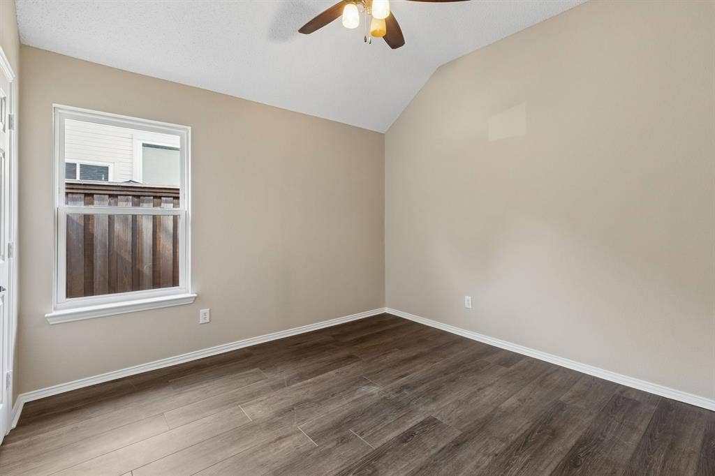 607 Grimsworth Court, Allen, TX 75002 Secondary bedroom has walk-in closet, laminateflooring, fresh paint, ceiling fan, and vaulted ceiling.