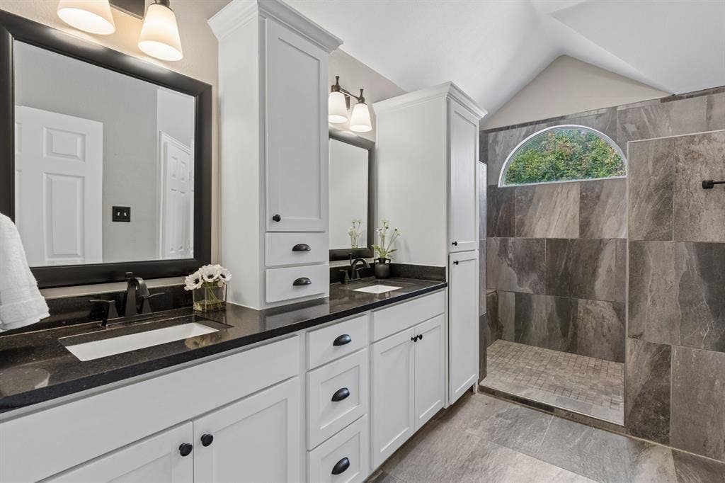 607 Grimsworth Court, Allen, TX 75002 The updated primary bathroom has great storage along with quartz countertops, white cabinets and wave sinks.