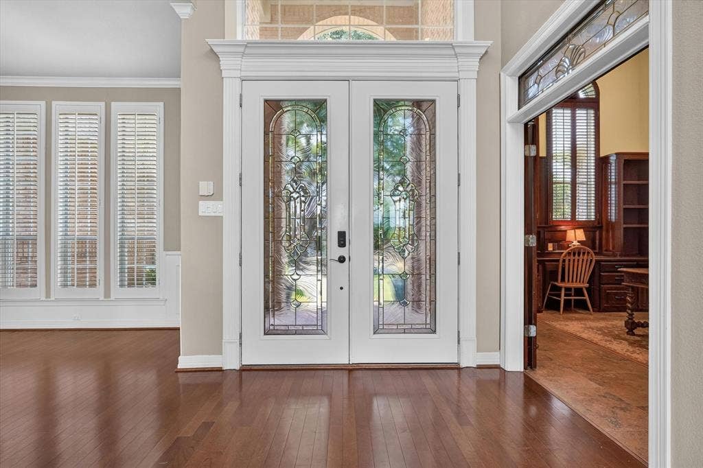 Double-door entry with decorative glass panels and transom window