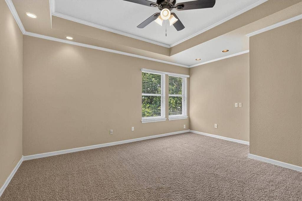 Spacious room featuring tray ceiling with a ceiling fan and recessed lighting
