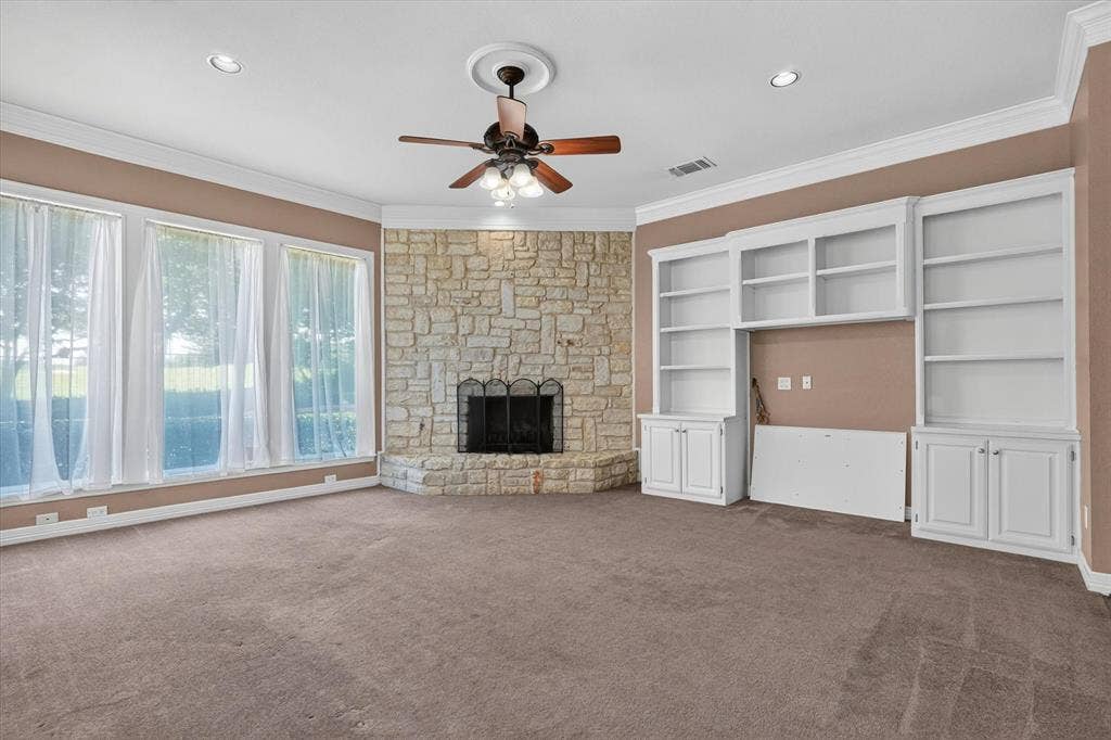 Spacious interior featuring a stone fireplace, recessed lighting, and a ceiling fan