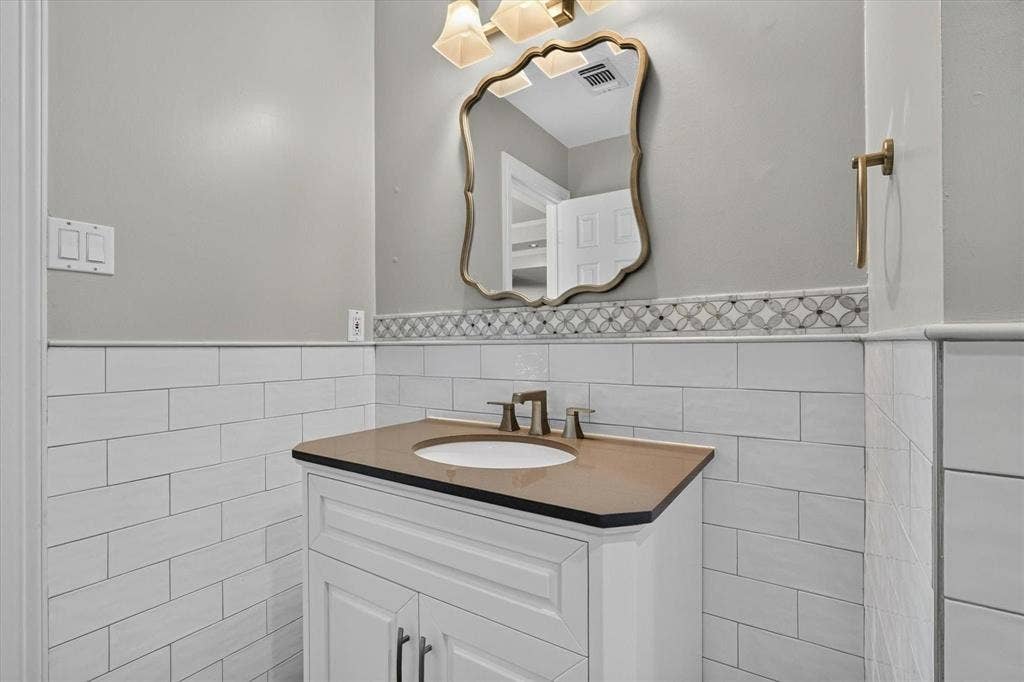 White vanity with a brown countertop and integrated sink