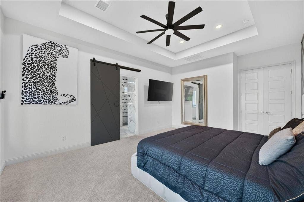 Recessed lighting and a tray ceiling with a modern ceiling fan