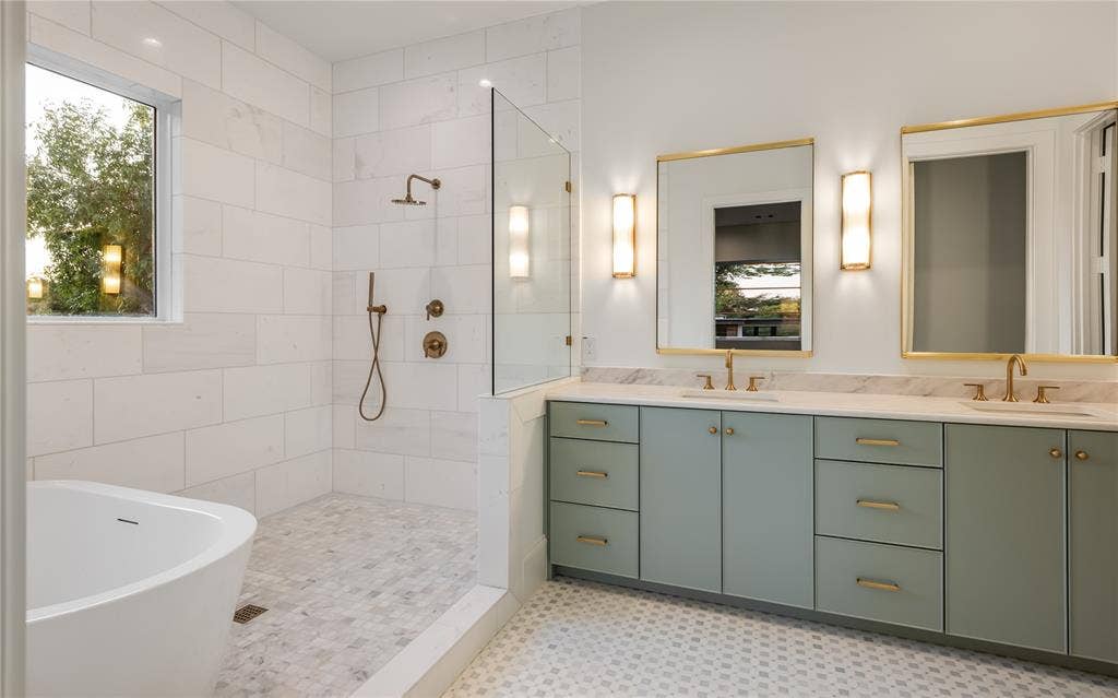 Walk-in shower with a glass enclosure, freestanding soaking tub, and a dual vanity with undermount sinks