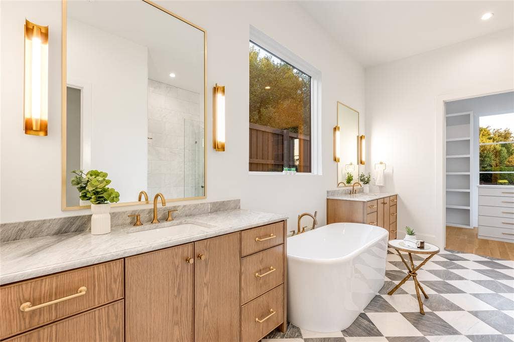 Dual wood-finish vanities with undermount sinks and gold-tone fixtures
