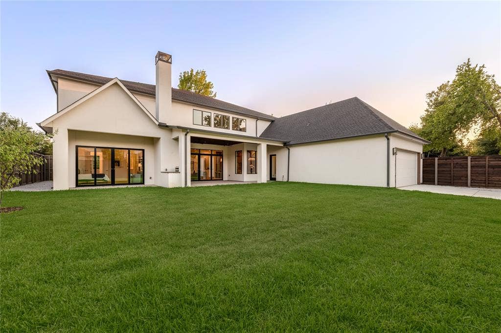 Expansive backyard with a manicured lawn, concrete patio, and a modern horizontal slat fence