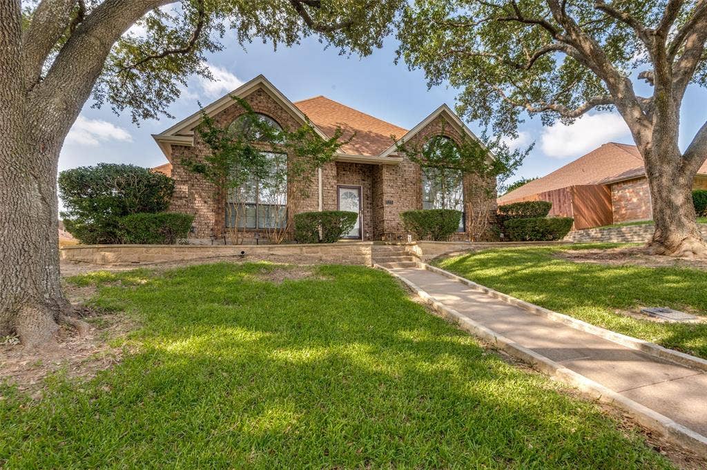 Brick facade residence featuring two prominent arched windows
