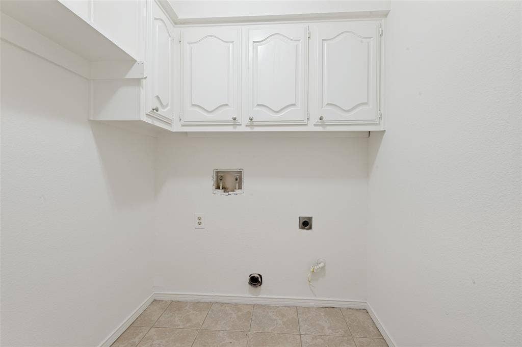 Laundry area featuring white cabinetry, tile flooring, and appliance hookups