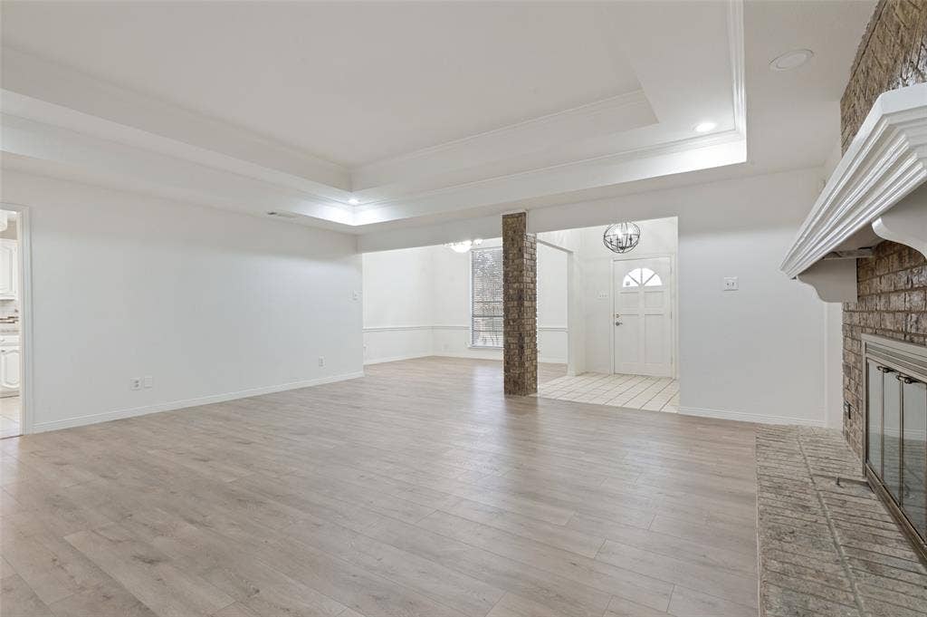 Living area featuring wood-finish flooring and a tray ceiling with recessed lighting