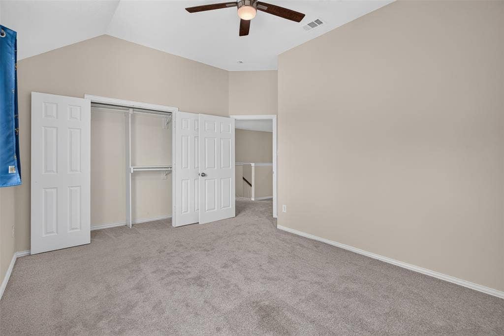 7112 Chandler Drive, Plano, TX 75024 Bedroom featuring vaulted ceilings, neutral wall paint, and soft gray carpeting