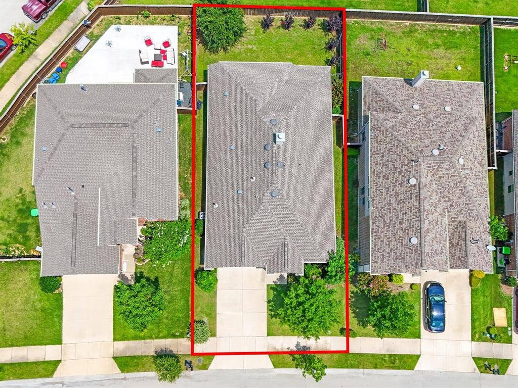 Aerial depiction of a residential property featuring a large backyard with a concrete patio