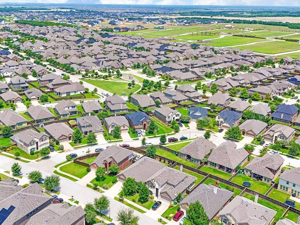 Aerial perspective showcasing a residential community with numerous single-family homes, each featuring individual landscaping