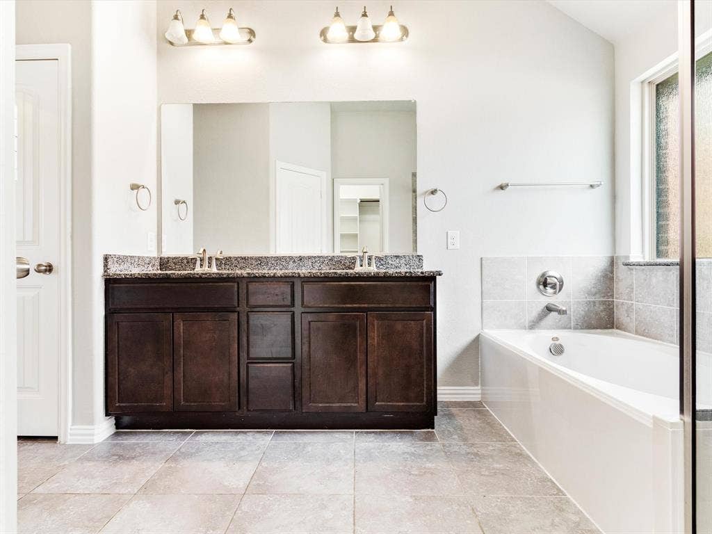 Dual vanity with dark wood cabinetry and stone-finish countertop