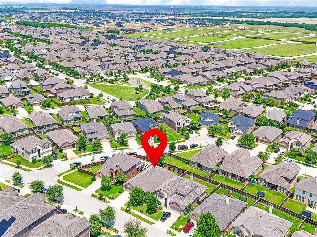 Aerial view of a residential neighborhood featuring numerous single-family homes with pitched roofs and green lawns